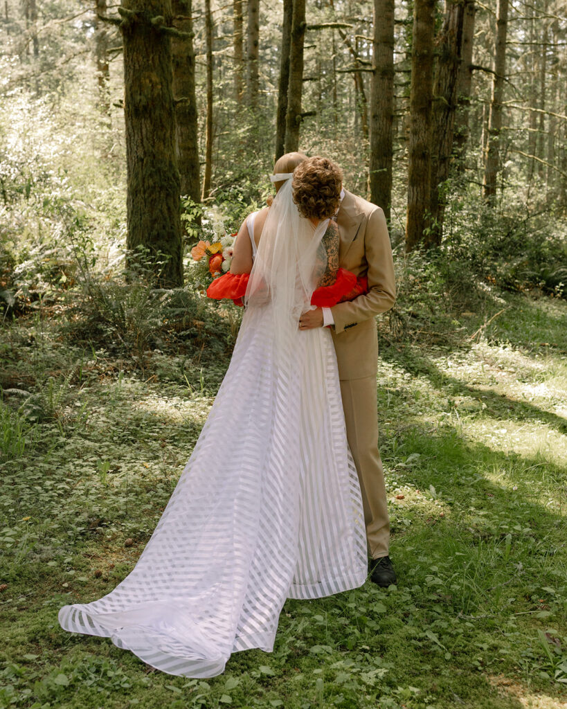 Washington newlyweds share an embrace in the forest where they exchanged vows during their Vashon wedding 