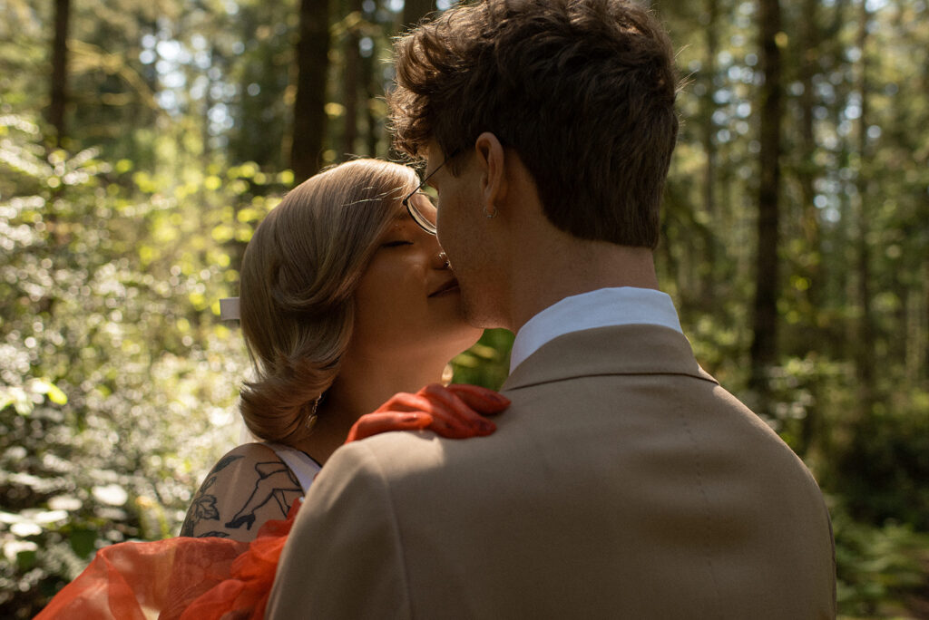 Newlyweds share a kiss in the forest following their private Vashon wedding 