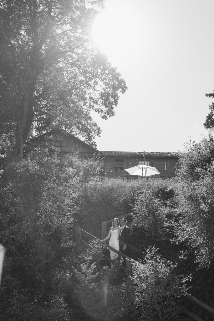 A bride and groom stand side by side in front of the lodge at their Captain Whidbey Inn wedding 
