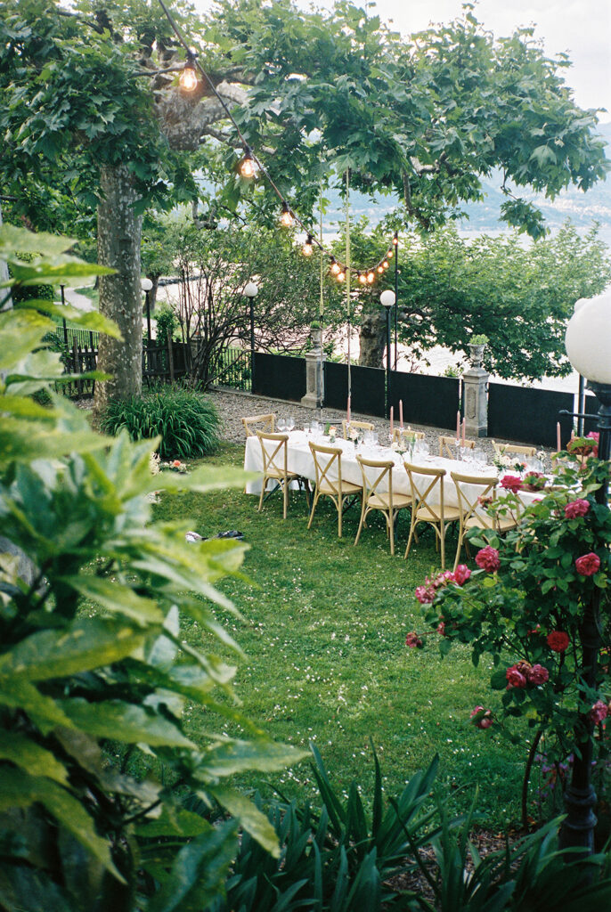 Reception decor featuring a long family style table and string lighting is shown at Villa la Felice 