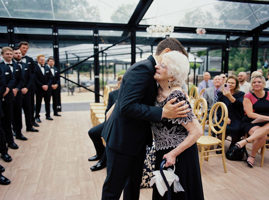 A groom hugs his grandmother who acted as flower girl at his bavaria downs chaska mn wedding 
