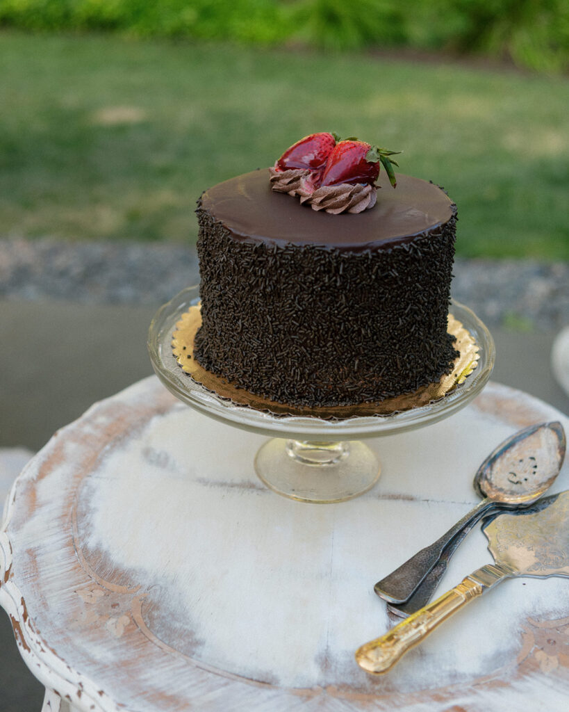A chocolate wedding cake topped with strawberries is photographed at a hood river wedding