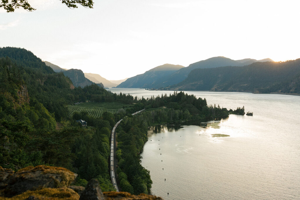 A landscape photo depicts Columbia River Gorge at golden hour from a cliffside vantage point at the griffin house hood river, or