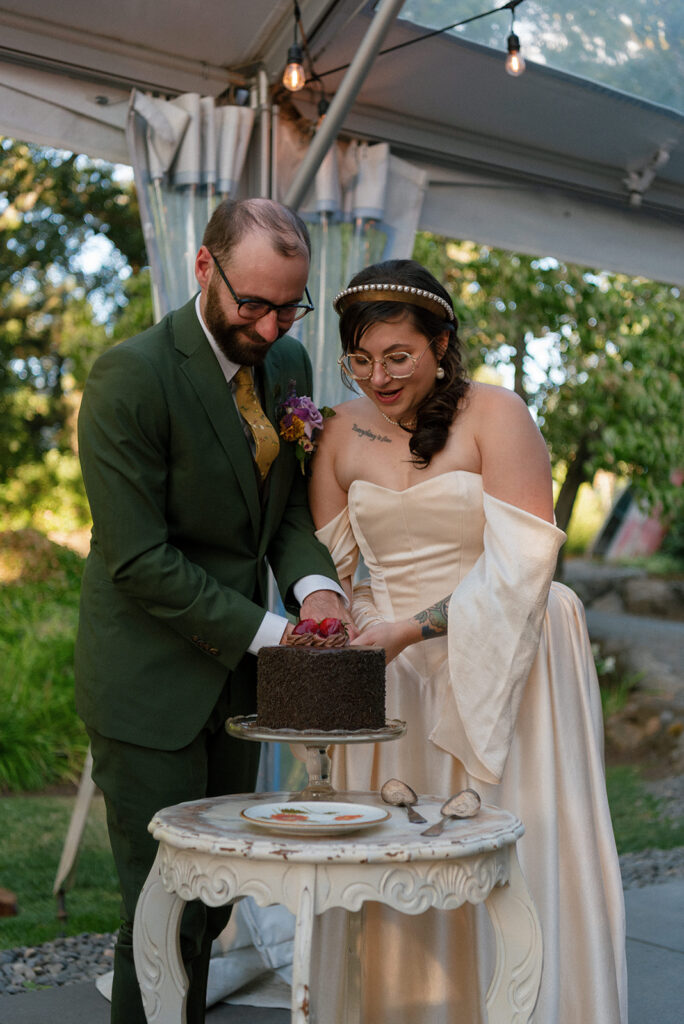 Newlyweds cut their chocolate cake at their griffin house hood river wedding reception