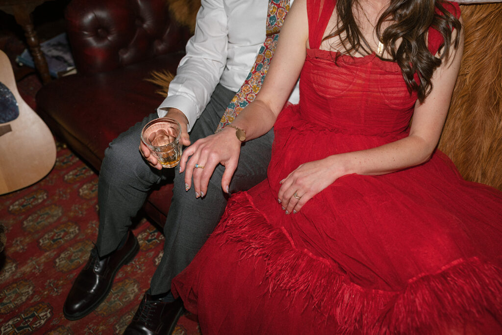 A close up photo shows a bride & groom seated on a leather couch at their tokeland hotel wedding