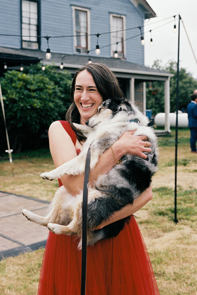 A smiling bride holds her dog at her tokeland hotel wa wedding 