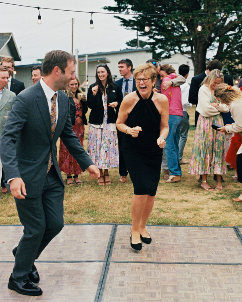 A groom laughs and dances with a guest at his Tokeland Hotel Tokeland WA wedding reception