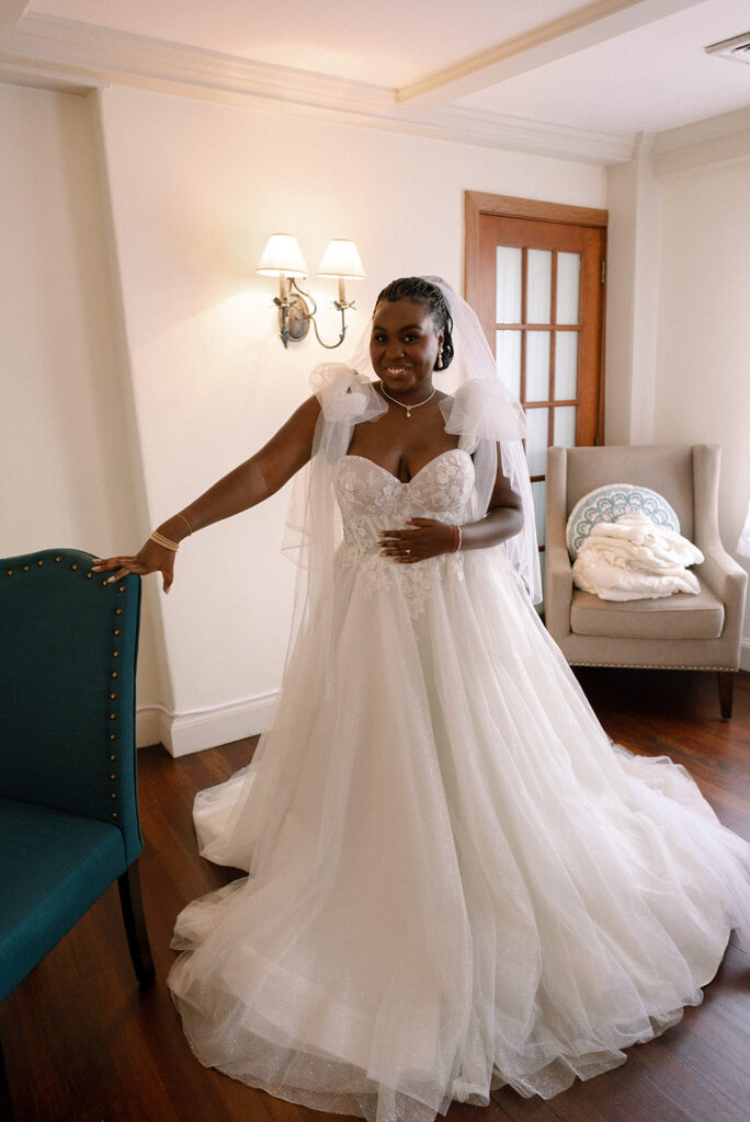A bride poses in her wedding gown before her New England wedding at Barker House, a waterfront wedding venue in  Massachusetts