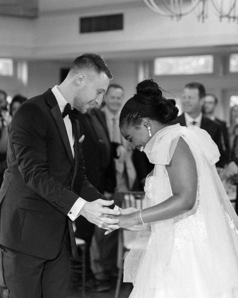 Newlyweds hold hands in a black and white photo taken at a barker tavern wedding 
