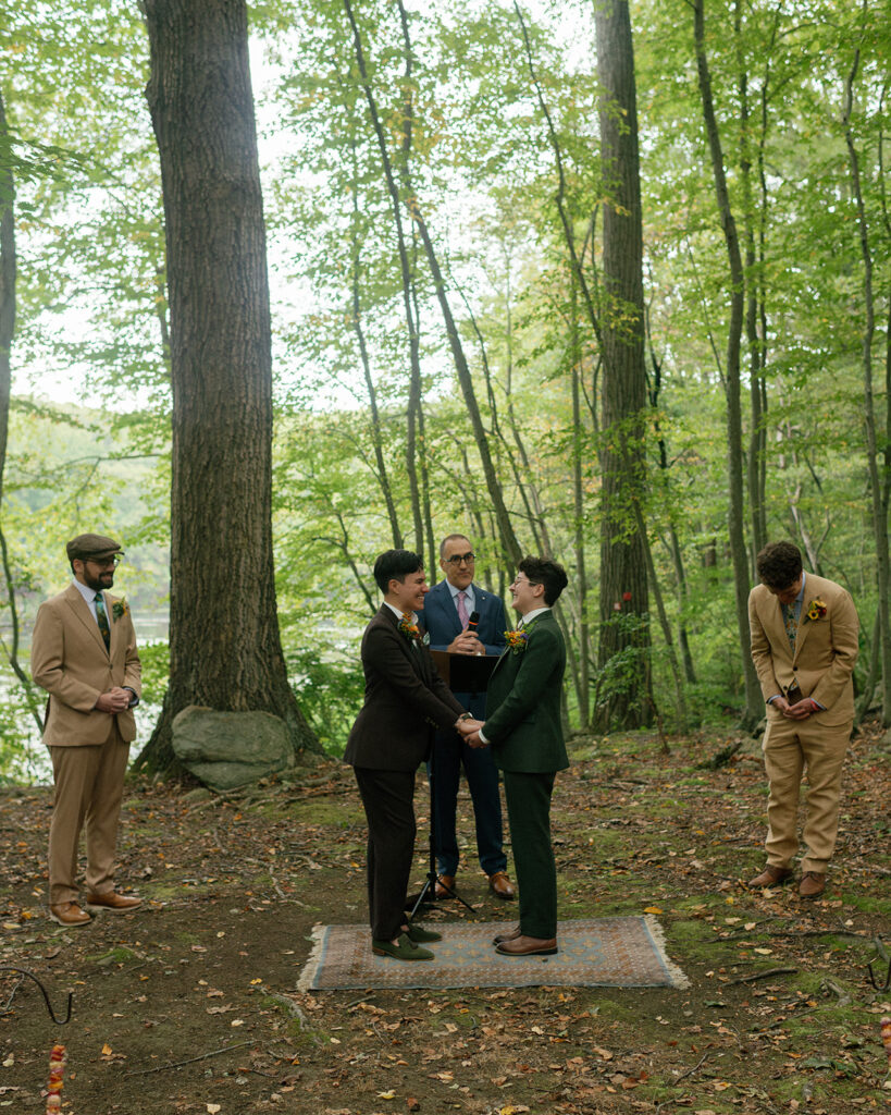 A forest wedding  ceremony at mountain lakes park westchester is shown in a photo taken by LGBT wedding photographer, Mossfloor