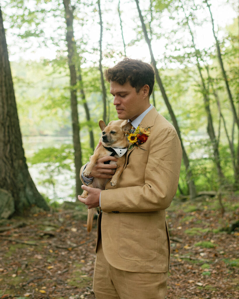 The best man holds the ring bearer, the couple's chihuahua, in a photo taken at a wedding ceremony in mountain lakes park westchester