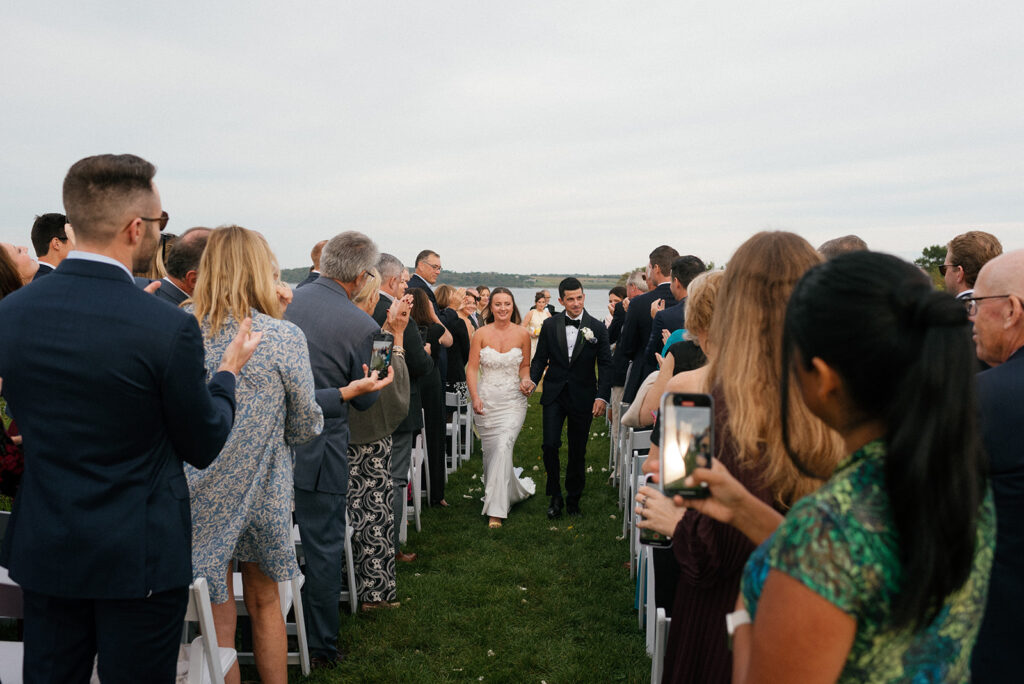 Newlyweds walk down the aisle following their waterfront ceremony at Greenvale Vineyards wedding 